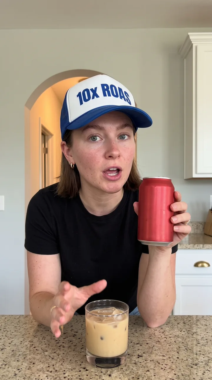 Lifestyle AI UGC ad still: Kitchen counter demo. Cap on, can up, mid-sentence.